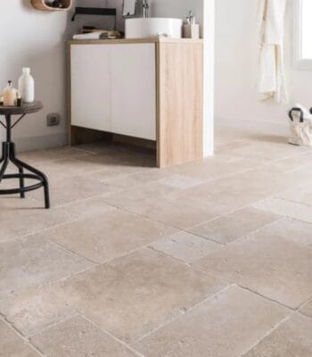 Badkamer met een lichte travertin vloer in Romeins verband en een wastafelmeubel van hout